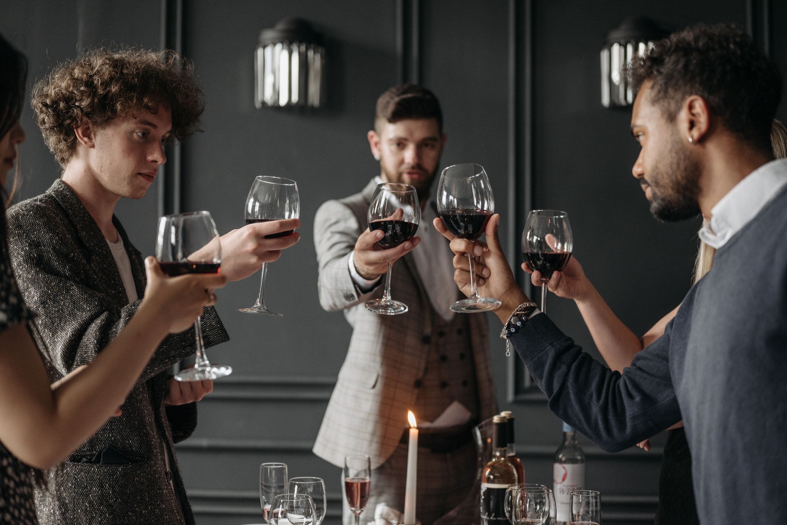 Members of many nationalities raising glasses together in a softly lit private room